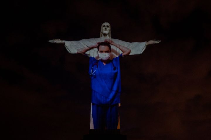 View of a medical worker on the illuminated statue of Christ the Redeemer.