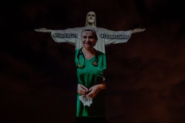 View of a medical worker on the illuminated statue of Christ the Redeemer.