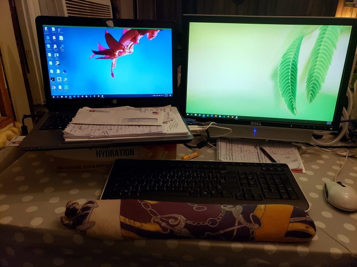 To make her new office more ergonomic, systems analyst Angie Wilbur used an old shampoo box for a monitor riser and a wrist rest made from socks and rice on her dining room table.