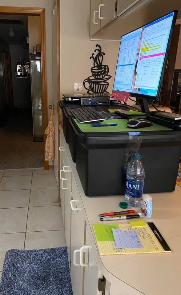 Billing analyst Elizabeth Goecke created a standing desk with three plastic storage boxes on her kitchen counter, and made a padded mat using two bath rugs folded in half.