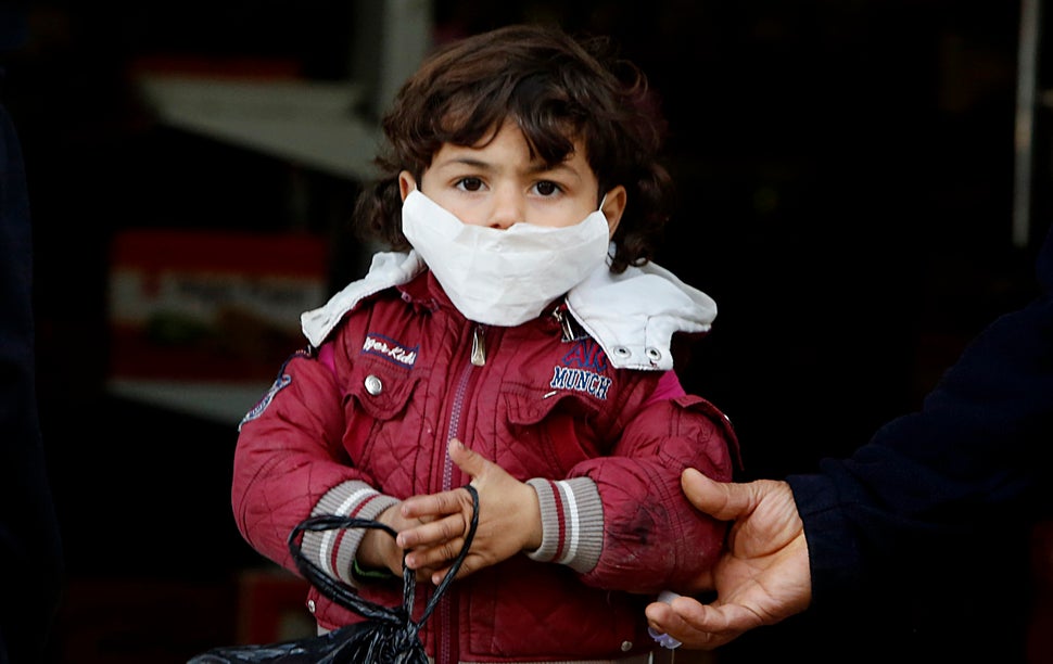 A Palestinian child wears a face mask as he plays outside his home in Shati refugee camp, west Gaza City, March 25, 2020.