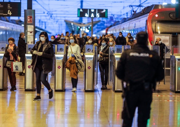 Un polic&iacute;a entrega mascarillas en la estaci&oacute;n del Norte en Valencia tras la vuelta al trabajo...