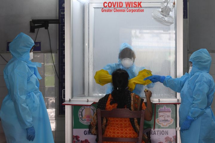Medical staff collects a sample from a woman at a COVID-19 testing centre in Chennai on April 14, 2020.