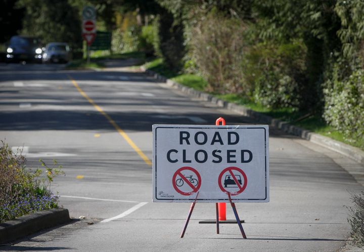 A sign is pictured on the road to Stanley Park to prohibit vehicles in order to maintain social distancing in Vancouver on April 7, 2020.