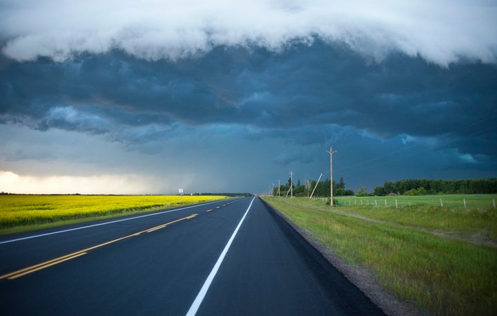 This undated stock photo shows an empty two-lane highway in rural Alberta, with the dark clouds of a storm on the horizon.