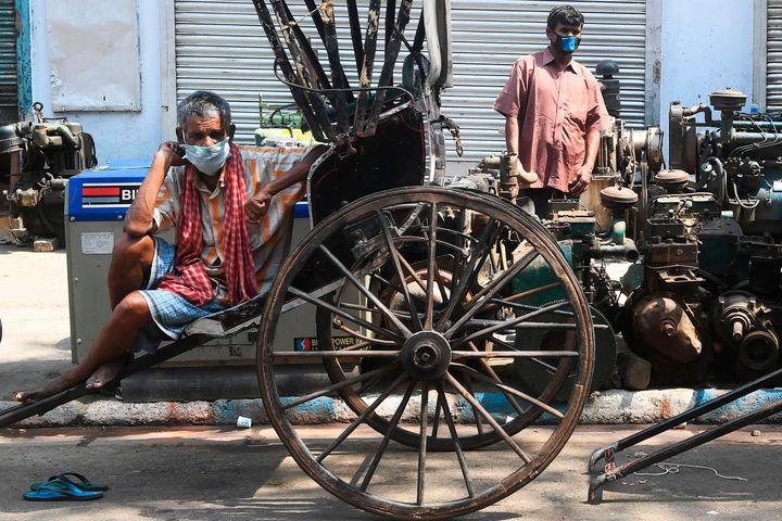 Rickshaw pullers wait for customers during a government-imposed nationwide lockdown as a preventive measure against the COVID-19 coronavirus, in Kolkata on April 14, 2020.