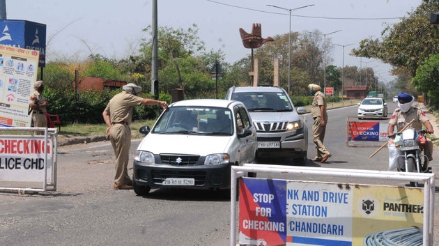 Police personnel screen vehicles for identity cards during the lockdown, at Chandigarh - Zirapur boarder...