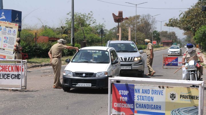 Police personnel screen vehicles for identity cards during the lockdown, at Chandigarh - Zirapur boarder on April 14, 2020 in Chandigarh.