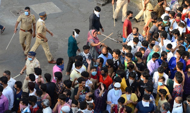 Police try to control migrant workers protesting against the the extension of the lockdown in Mumbai,...