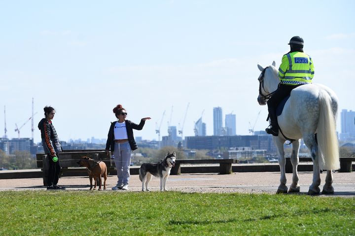 Mounted police officers speak to people on Primrose Hill, London, as the UK continues in lockdown to help curb the spread of the coronavirus.
