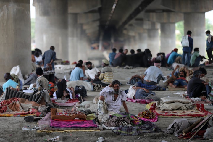 Migrant workers and homeless people take refuge under a bridge on the banks of the Yamuna River in New Delhi during a nationwide lockdown on April 14, 2020.