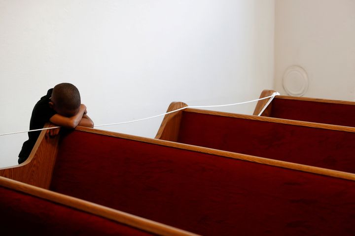 A 5-year-old child put his head down on an empty pew at a church in Oakland, California, on March 22.