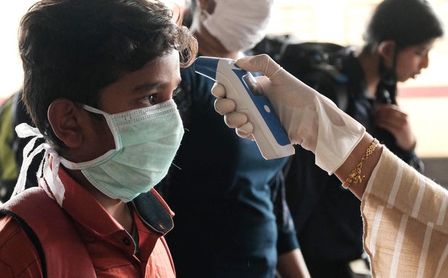 A health official of Kerala government checks the temperature of a boy at Kochi in Kerala, March 23,