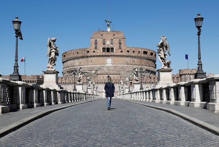 A woman wearing a protective mask walks outside Castel Sant'Angelo in Rome, Italy, on March 23.