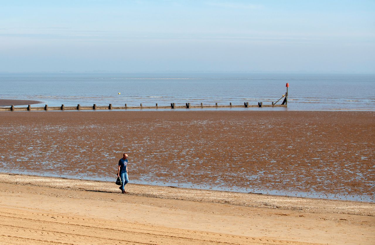 A man walks along the beach in Cleethorpes as the UK continues in lockdown to help curb the spread of the coronavirus. (Photo by Danny Lawson/PA Images via Getty Images)