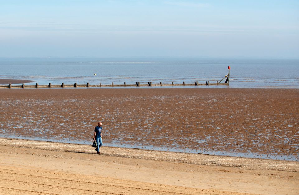 A man walks along the beach in Cleethorpes as the UK continues in lockdown to help curb the spread of the coronavirus. (Photo by Danny Lawson/PA Images via Getty Images)