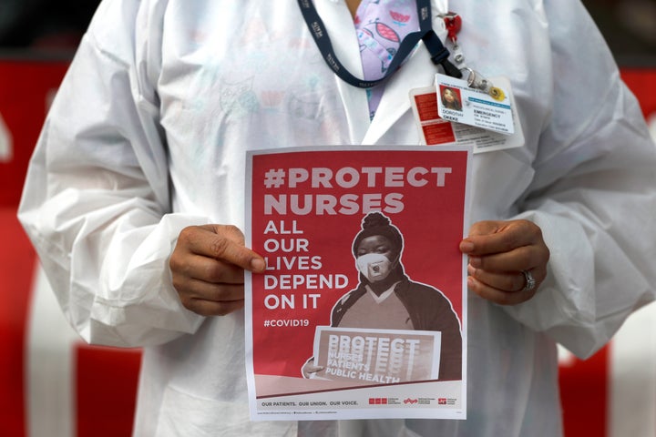 A nurse at Provident Hospital of Cook County holds a sign as she participates in an after shift demonstration on April 6 in Chicago's Hyde Park neighborhood.