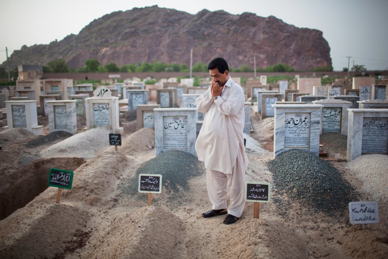 Muhammad Munawar prays at the grave of his slain son, 17-year-old Waleed, in Chenab Nagar, Pakistan. Waleed, a medical student, was murdered in May 2010 during attacks on two Ahmadi mosques in Lahore that killed 93 people and injured more than 100. (Daniel Berehulak/Getty Images)