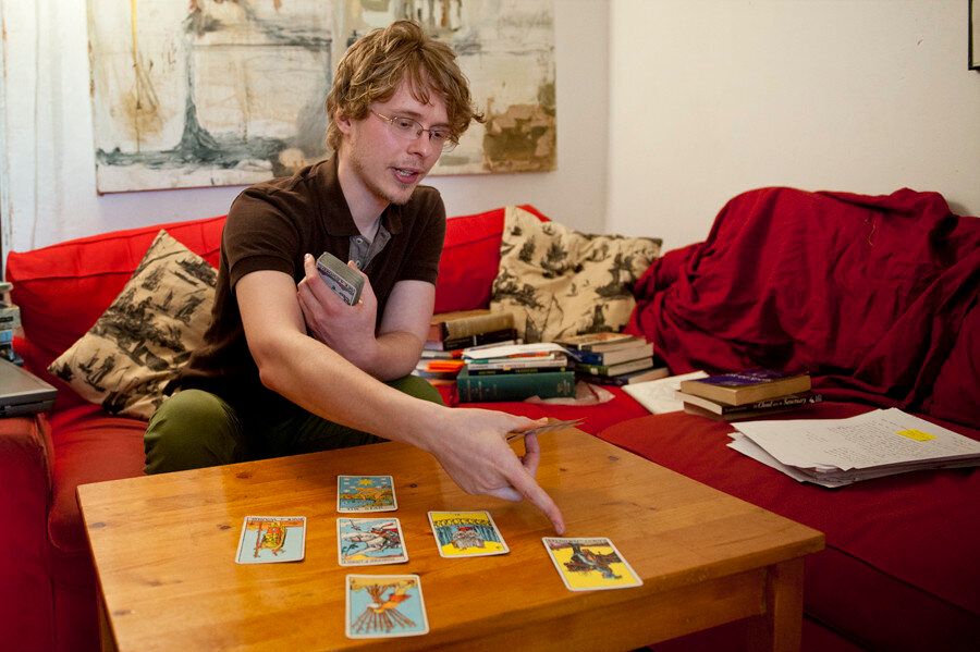 Stuart explains a card in his apartment in Bushwick, Brooklyn. (Wendy George/Huffington Post)