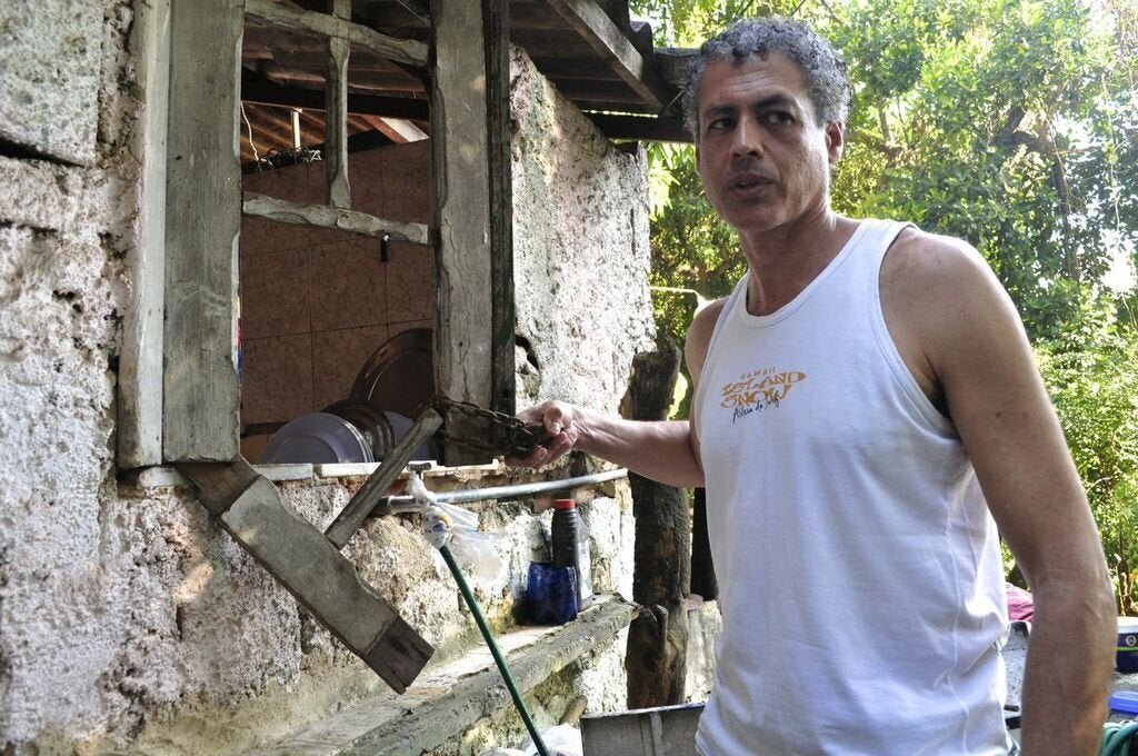 José Claudio Pinto holds the lock that was once used to keep the windows of quilombo Sacopã's kitchen shut. (Carolina Ramirez/The Huffington Post)