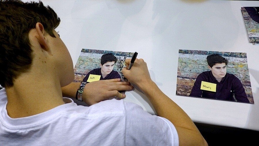 <div class="feature-caption"><em> Nash signs two of several hundred photos he autographed in the course of one afternoon at Wizard World. (Photo by Bianca Bosker)</em></div>