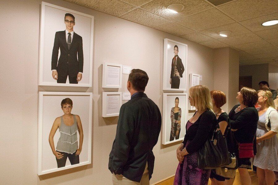 Guests look at the "Family Matters" photographs on opening night. (Photo by Cary Norton)