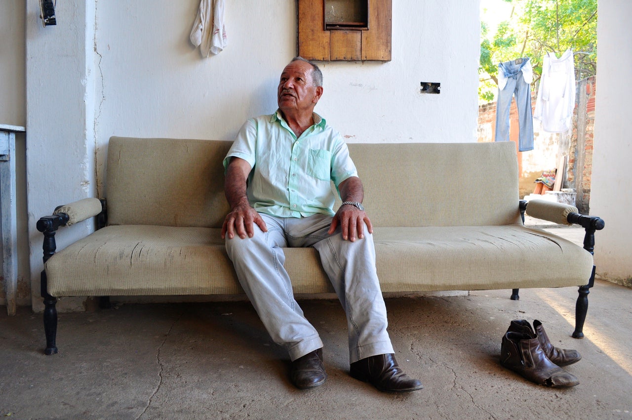 Hélio Pereira Pinto, seated on a sofa at his home in Barra do Parateca, is one of several people with whom the quilombo association has a land dispute. (Carolina Ramirez/The Huffington Post)