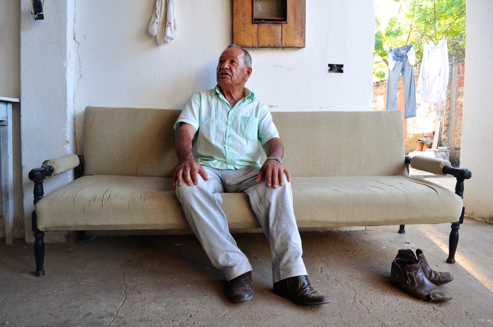 <em>Hélio Pereira Pinto, seated on a sofa at his home in Barra do Parateca, is one of several people with whom the quilombo a