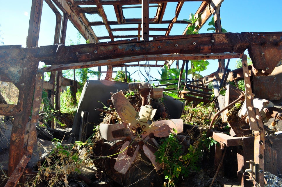 <em>The charred remains of a bus set ablaze in 2010 remain standing on the main street of Barra do Parateca, Brazil. (Carolin
