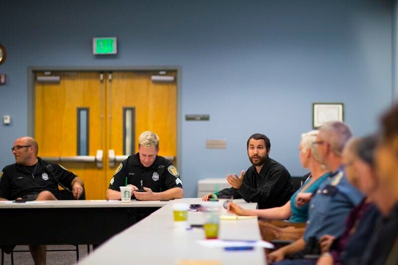 <em> LEAD (Law Enforcement Assisted Diversion) caseworker Tim Candela, right, attends a LEAD meeting at the SPD West Precinct in Seattle on Wednesday, Aug. 13, 2014. Mike Kane for The Huffington Post</em>