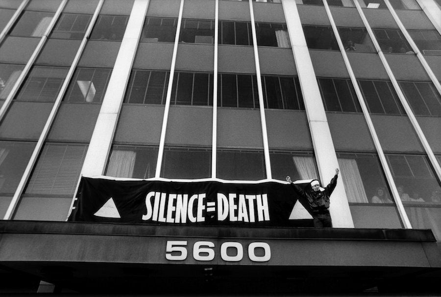 This Oct. 11, 1988, photo shows Peter Staley in a scene from the documentary "How to Survive a Plague.” Staley triumphantly finishes hanging a banner over the entrance to the FDA main headquarters, during an HIV/AIDS civil disobedience demonstration, in Rockville, Maryland. (AP Photo/Sundance Selects, Rick Reinhard)