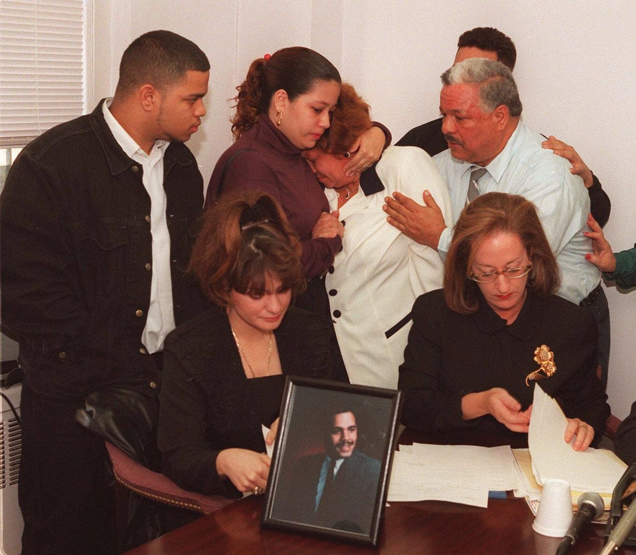 The family of Anthony Baez, who died in police custody on Dec. 22, react Dec. 29, 1994, during a news conference in New York in which they called for a grand jury investigation. Baez's widow, Miranda, is seated left, with Susan Karten, a lawyer, at right. Standing, from left, are Baez's brother David; sister, Elizabeth; mother, Iris; and father, Anthony Sr. (AP Photo/Luc Novovitch)