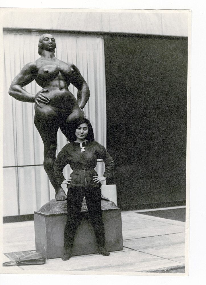 Yoko Ono with Standing Woman (1932) by Gaston Lachaise, The Museum of Modern Art Sculpture Garden, New York. c. 1960–61. Photograph by Minoru Niizuma. © Minoru Niizuma. Courtesy Lenono Photo Archive, New York