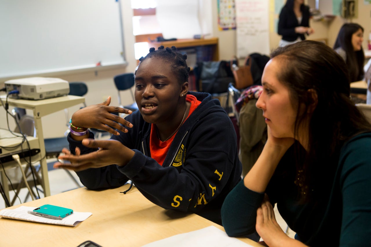 <em>Amanda de la Torre, 26, listens as her mentee Angela Opoku, 15, speaks to the group. </em>