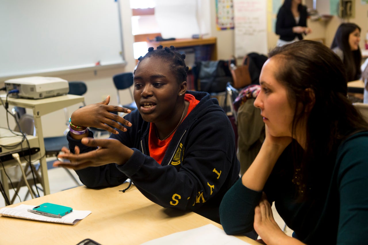 Amanda de la Torre, 26, listens as her mentee Angela Opoku, 15, speaks to the group. 