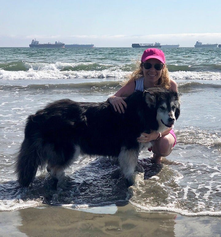Black with her dog, Bear, at Pink Beach.