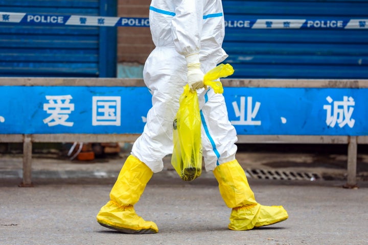 Health A worker in Wuhan, China, takes away an escaped giant salamander just caught in Huanan Seafood Market on Jan. 27. The market 