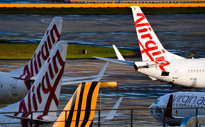 Planes from Australian airlines Tiger Air and Virgin sit idle on the tarmac at Melbourne's Tullamarine Airport on April 12, 2020.