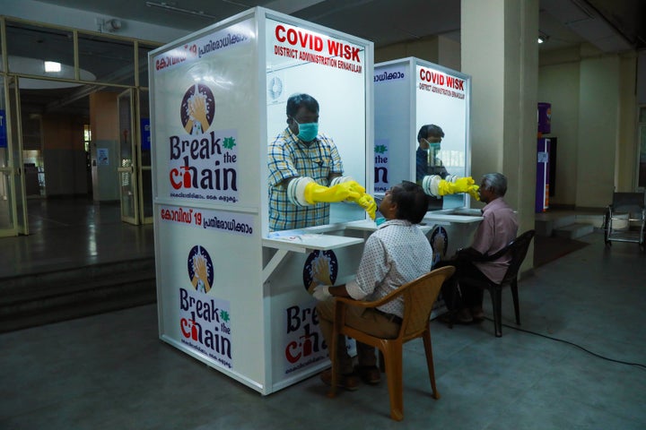 Medical staff collect samples from people at newly set upped Walk-In Sample Kiosk (WISK) to test for the COVID 19 coronavirus at Ernakulam Medical College in Kerala on April 6, 2020.