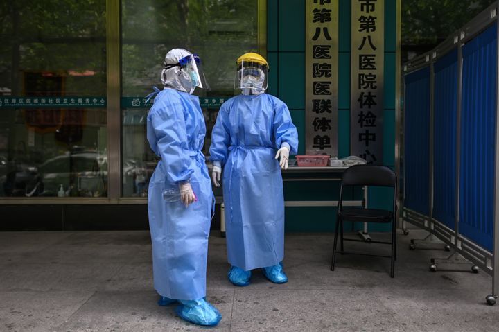 Medical workers are seen as they take swab samples from people to be tested for the COVID-19 novel coronavirus in Wuhan, China's central Hubei province on April 16, 2020.