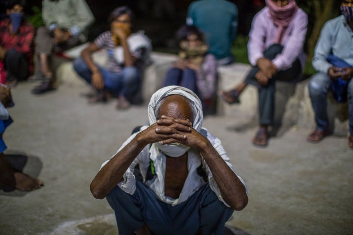 Indian migrant workers and homeless people wait for food outside a government-run shelter in New Delhi on 9 April, 2020. 