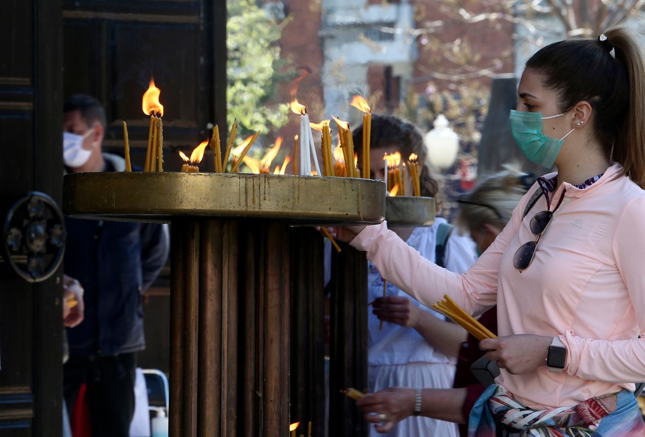 Πιστοί ανάβουν κεριά φορώντας μάσκες υπό τον φόβο του κορονοϊού στα Σκόπια, καθώς ούτε στη Βόρεια Μακεδονία επιτρέπεται αυτό το Πάσχα να γεμίσουν οι εκκλησίες... (AP Photo/Boris Grdanoski)