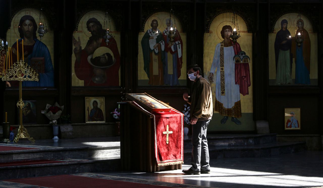 Πιστοί ανάβουν κεριά φορώντας μάσκες υπό τον φόβο του κορονοϊού στα Σκόπια, καθώς ούτε στη Βόρεια Μακεδονία επιτρέπεται αυτό το Πάσχα να γεμίσουν οι εκκλησίες... (AP Photo/Boris Grdanoski)
