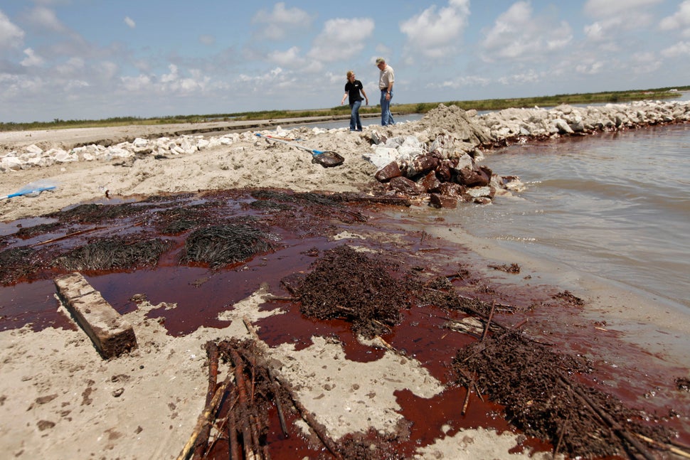 Oil washes ashore against a land bridge built by the Louisiana National Guard to hold back oil from the Deepwater Horizon oil