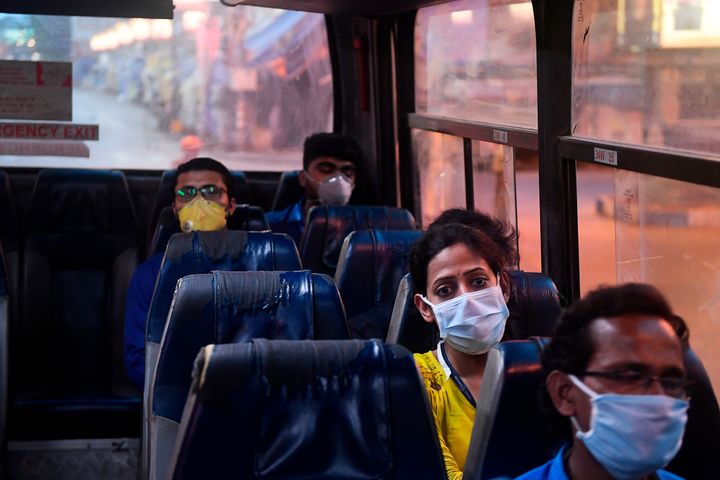 Essential workers sit in a government bus as they return home during a government-imposed nationwide lockdown in Kolkata on April 17, 2020. 