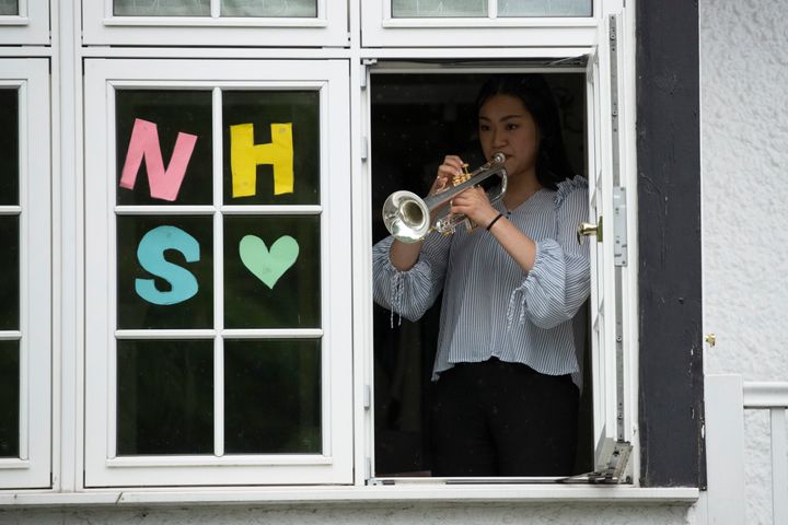 National Youth Orchestra of Great Britain trumpet player Tian Hsu, 16, takes part in a socially distanced orchestra performance of Beethoven's "Ode to Joy" from a window of her home in south west London.
