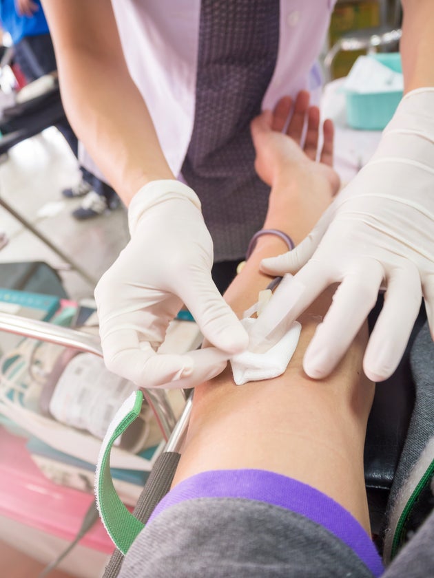 Nurse receiving blood from blood donor in hospital.