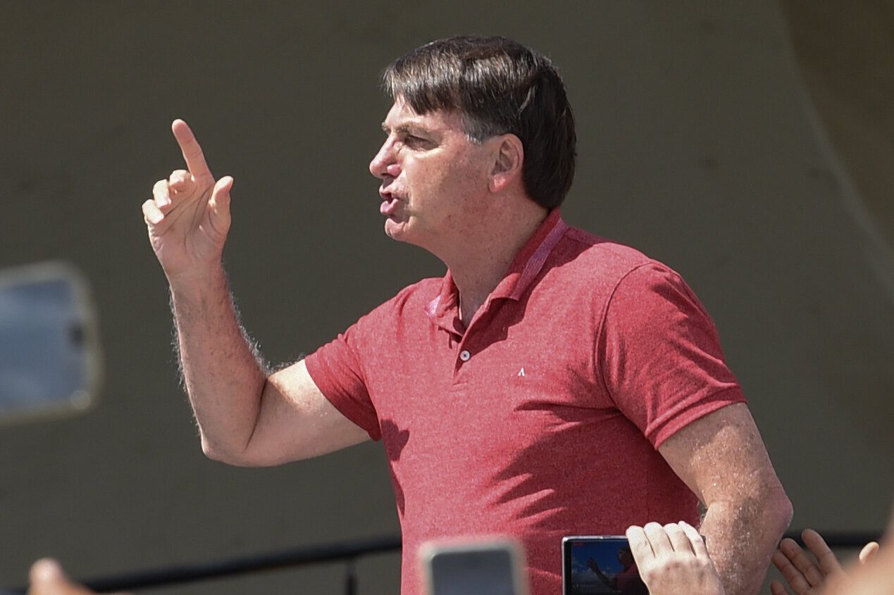 Brazilian President Jair Bolsonaro speaks after joining his supporters who were taking part in a motorcade to protest against quarantine and social distancing measures to combat the new coronavirus outbreak in Brasilia on April 19.