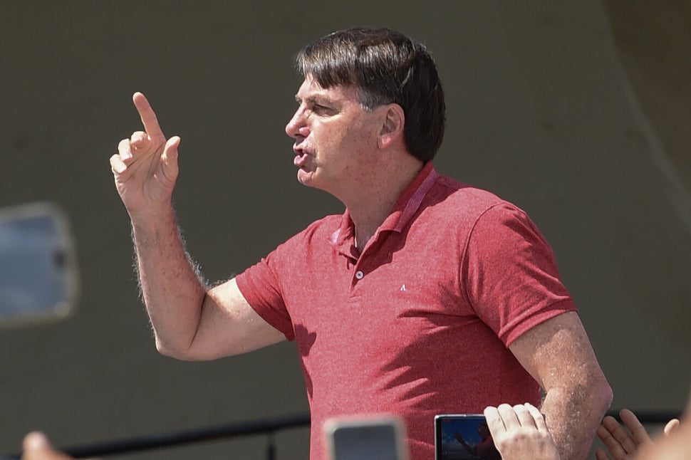 Brazilian President Jair Bolsonaro speaks after joining his supporters who were taking part in a motorcade to protest against