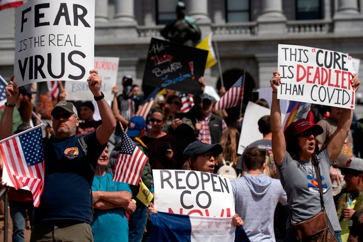 Demonstrators gather in front of the Colorado State Capitol building to protest coronavirus stay-at-home orders during a "ReOpen Colorado" rally in Denver, Colorado, on April 19, 2020. - Hundreds protested on April 18 in cities across America against coronavirus-related lockdowns -- with encouragement from President Donald Trump -- as resentment grows against the crippling economic cost of confinement. (Photo by Jason Connolly / AFP) (Photo by JASON CONNOLLY/AFP via Getty Images)